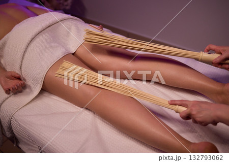 Experience relaxation and muscle relief with a spa treatment using bamboo sticks for rejuvenation 132793062