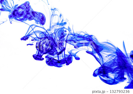 Blue ink injected into water from syringe, colour mixing with water creating abstract shapes 132793236