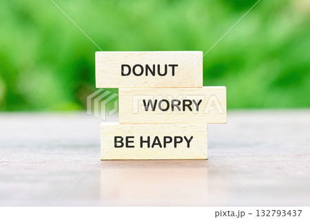 Wooden blocks stacked together display the fun phrase about joy and positivity, encouraging a lighthearted approach to life while surrounded by lush greenery and bright sunlight 132793437