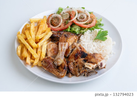 Grilled chicken rice fries salad, roasted chicken pieces with jasmine rice, golden fries and fresh tomato and onion rings, parsley garnish, casual bistro lunch 132794023