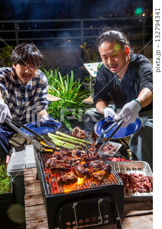 スペアリブのバーベキューをベランダで楽しむ男性 スペアリブのバーベキューをベランダで楽しむ男性 132794341