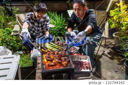スペアリブのバーベキューをベランダで楽しむ男性 132794342