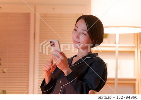 夜にスマホを見る若い女性 132794960