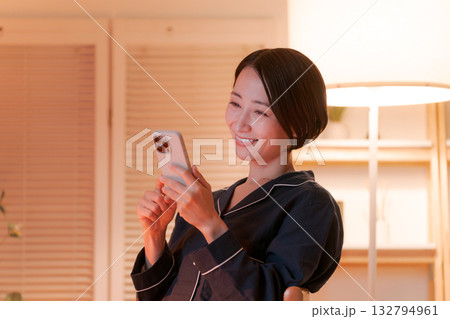 夜にスマホを見る若い女性 夜にスマホを見る若い女性 132794961