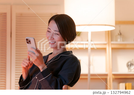 夜にスマホを見る若い女性 夜にスマホを見る若い女性 132794962