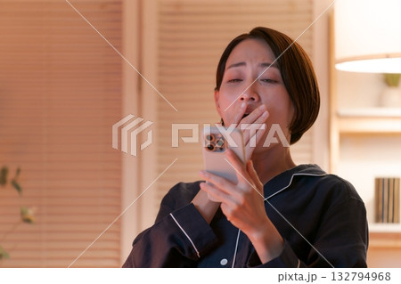 夜にスマホを見る若い女性 132794968