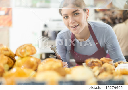 Young female waitress offers fresh pastries Young female waitress offers fresh pastries 132796064