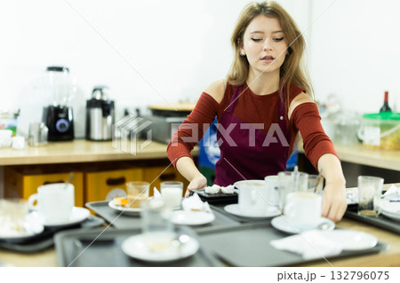 Cafe waitress carries a tray with dirty dishes closeup 132796075