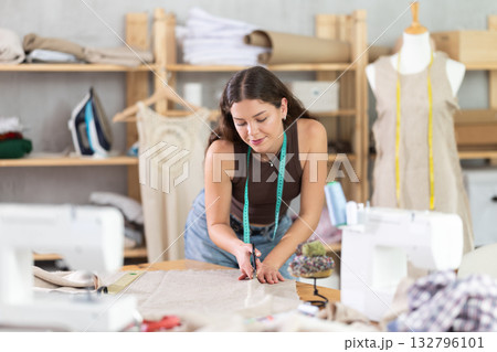 Woman tailor cutting fabric on table 132796101