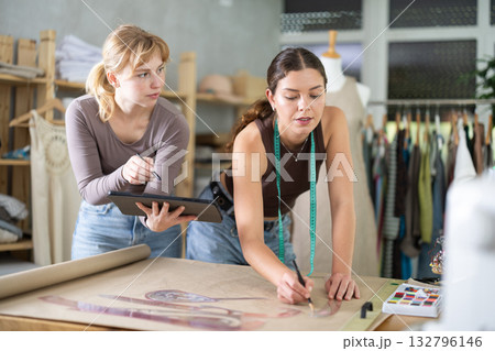 Female tailors working together in workshop with tablet and paper 132796146