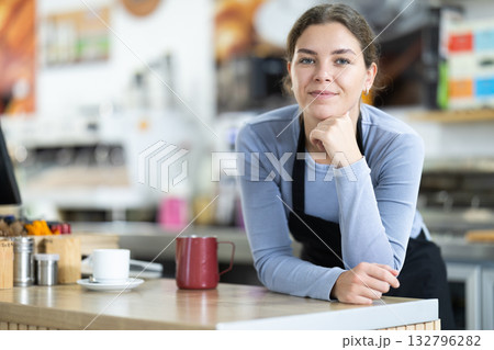 Young female barista serving coffee 132796282
