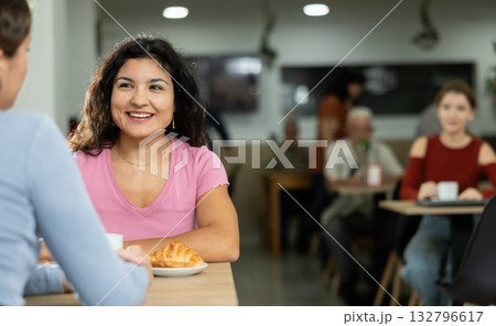 Young woman and her friend drinking coffee and talking 132796617