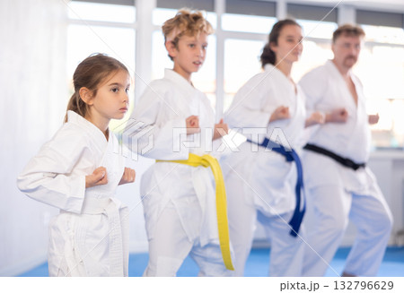 Family with children in kimono trying new martial moves at karate class 132796629