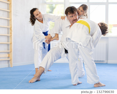 Family with children training karate fighting techniques 132796630