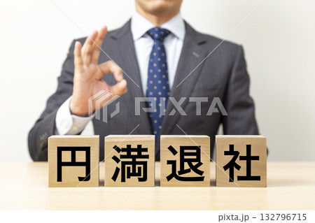 「円満退社」と書かれたブロックとOKポーズをするビジネスマン 「円満退社」と書かれたブロックとOKポーズをするビジネスマン 132796715
