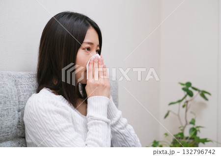 ティッシュで鼻をかむ女性のクローズアップ 132796742