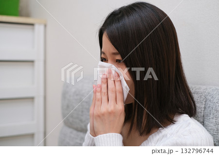 ティッシュで鼻をかむ女性のクローズアップ 132796744