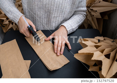 Process of preparing for Christmas star and New Year eve. 3D craft bag snowflakes DIY. Responsible ecological zero waste handmade decoration. Children hobby activity 132797520