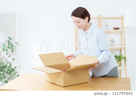 ダンボールに荷造りする女性 132797843