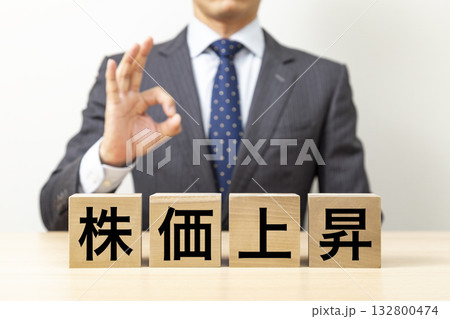 「株価上昇」と書かれたブロックとOKポーズをするビジネスマン 132800474