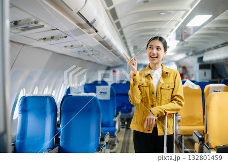 Attractive Asian female passenger of airplane sitting in comfortable seat while working laptop and tablet. Travel in style, work with grace. 132801459