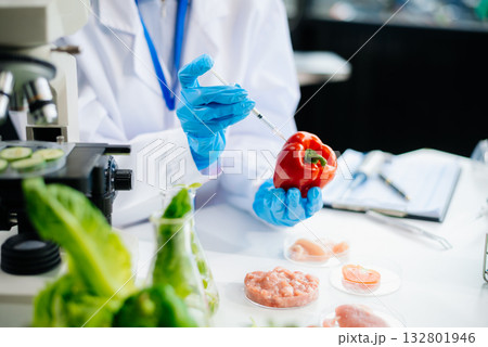 Two Asian scientists in a lab conducting food research using a microscope and lab equipment, showcasing innovation in food science 132801946
