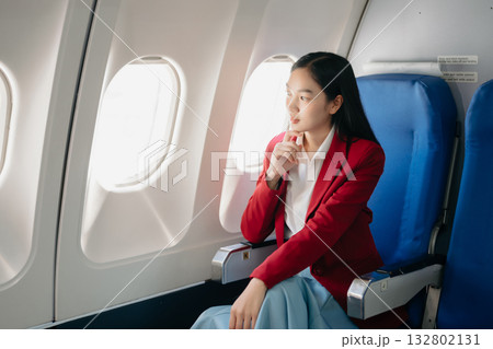 Photo of a frustrated woman sitting on an airplane with her head in her hands. woman sitting in a seat in airplane Photo of a frustrated woman sitting on an airplane with her head in her hands. woman sitting in a seat in airplane 132802131
