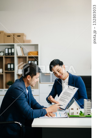 balancing the property sector The real estate agent is explaining the house style to see the house design and the purchase agreement. balancing the property sector The real estate agent is explaining the house style to see the house design and the purchase agreement. 132803033