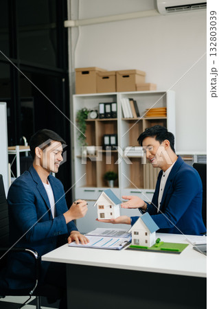 balancing the property sector The real estate agent is explaining the house style to see the house design and the purchase agreement. balancing the property sector The real estate agent is explaining the house style to see the house design and the purchase agreement. 132803039