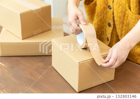 段ボールを梱包する手元 132803146