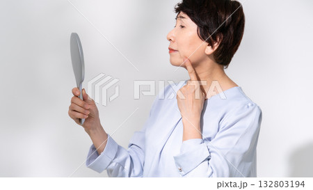 鏡を見るシニア女性　悩む 132803194