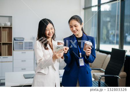Two business worker standing and holding a coffee cup in modern office, successful, celebration, new project, team office concept Two business worker standing and holding a coffee cup in modern office, successful, celebration, new project, team office concept 132803326