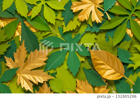 A composition of green, light green and gold artificial maple and grape leaves. 132805206