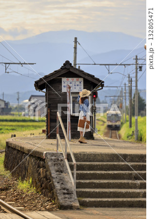 田舎の駅のホームで電車を待つ女性 132805471
