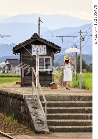 田舎の駅のホームで電車を待つ女性 田舎の駅のホームで電車を待つ女性 132805479