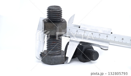 A caliper precisely measures the size of a bolt, showcasing mechanical accuracy. 132805793