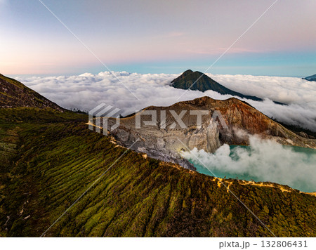 Aerial view of rock cliff at Kawah Ijen volcano with turquoise sulfur water lake at sunrise.Amazing nature landscape view at East Java, Indonesia.Natural landscape colorful sky background Aerial view of rock cliff at Kawah Ijen volcano with turquoise sulfur water lake at sunrise.Amazing nature landscape view at East Java, Indonesia.Natural landscape colorful sky background 132806431