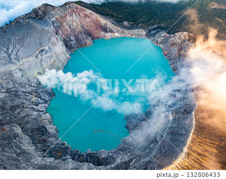 Aerial view of rock cliff at Kawah Ijen volcano with turquoise sulfur water lake at sunrise.Amazing nature landscape view at East Java, Indonesia.Natural landscape colorful sky background 132806433