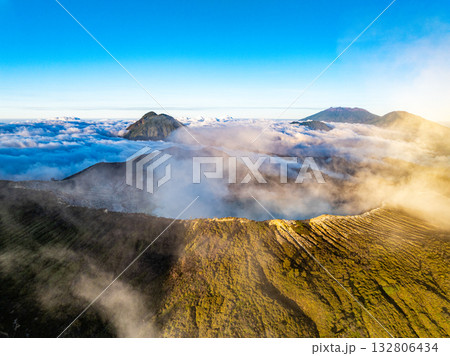Aerial view of rock cliff at Kawah Ijen volcano with turquoise sulfur water lake at sunrise.Amazing nature landscape view at East Java, Indonesia.Natural landscape colorful sky background 132806434