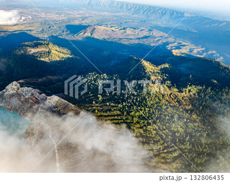 Aerial view of rock cliff at Kawah Ijen volcano with turquoise sulfur water lake at sunrise.Amazing nature landscape view at East Java, Indonesia.Natural landscape colorful sky background 132806435