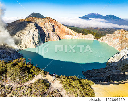 Aerial view of rock cliff at Kawah Ijen volcano with turquoise sulfur water lake at sunrise.Amazing nature landscape view at East Java, Indonesia.Natural landscape colorful sky background 132806439