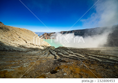 Aerial view of rock cliff at Kawah Ijen volcano with turquoise sulfur water lake at sunrise.Amazing nature landscape view at East Java, Indonesia.Natural landscape colorful sky background 132806453