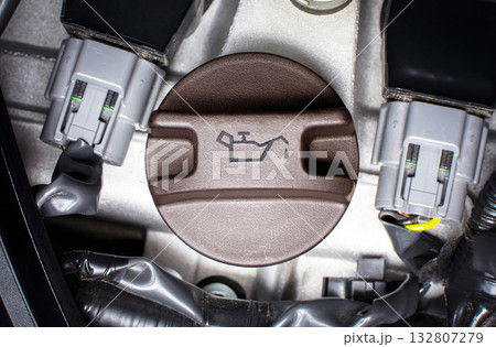 Close-up of an engine oil cap with oil symbol, motor oil change, engine lubrication Close-up of an engine oil cap with oil symbol, motor oil change, engine lubrication 132807279