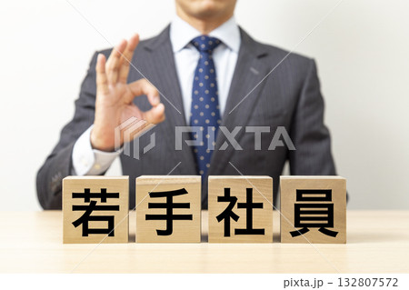 「若手社員」と書かれたブロックとOKポーズをするビジネスマン 132807572