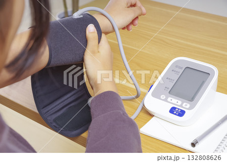 家庭用血圧計で血圧を測定する人の手元 132808626