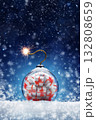Christmas card with a Christmas ball and a gift inside in the form of a bomb on the snow. Festive banner with hoarfrost on night abstract defocused lights background. 132808659
