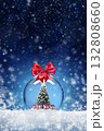 New years card with a ball toy and a Christmas tree with gifts inside on the snow. Festive banner with hoarfrost on the background of night abstract defocused lights. 132808660