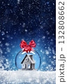Christmas card with a toy ball and a house inside on the snow. Festive banner with hoarfrost on night abstract defocused lights background. 132808662