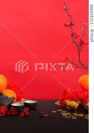 Chinese New Year celebration with tea set, oranges, and decorative flowers 132810308