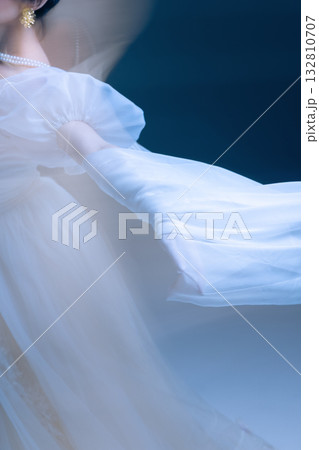 Flowing motion of dancer in white fabric, blurred movement radiating calm 132810707